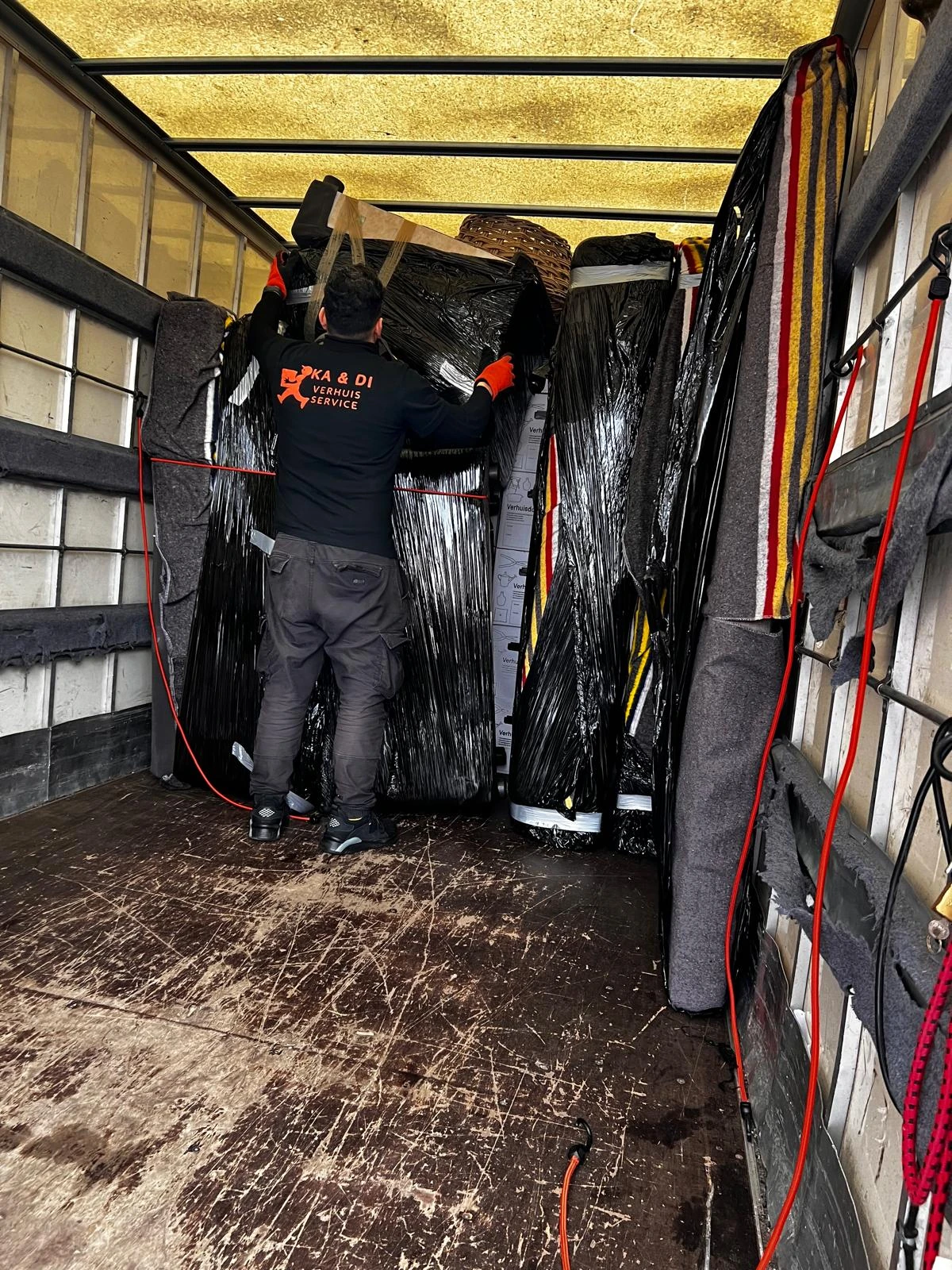 KADI-verhuizer zet ingepakte meubels vast in de bakwagen